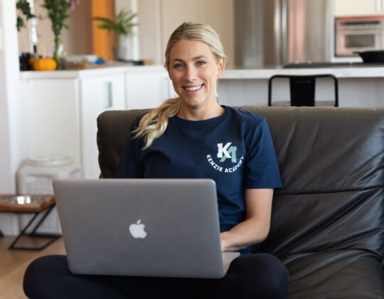 woman sitting on couch coding on a laptop.